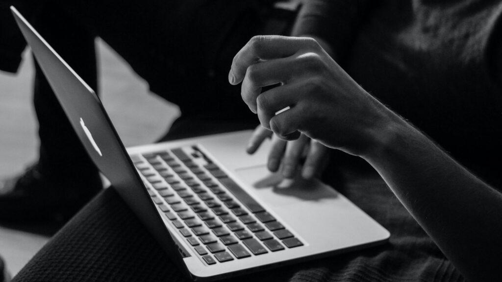 Hände auf einer Laptop-Tastatur – Firmenänderung mit qualifizierter elektronischer Signatur
