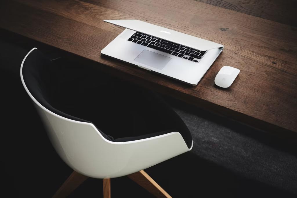 Schreibtisch mit Laptop und weissem Stuhl – Firmenänderungen wie Sitz, Zweck, Name und Statuten